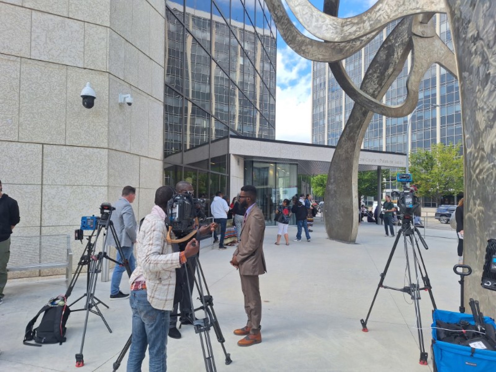 JRD Kwilu speaking with television crews outside the Winnipeg Law Courts